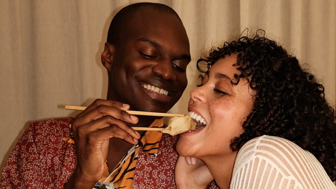 Ein Mann füttert einer Frau Dumplings der Bistronomie Baobei